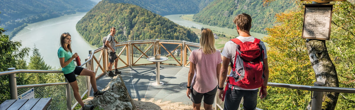 Wanderer genießen den Panoramablick auf die Schlögener Donauschlinge vom Wanderweg
